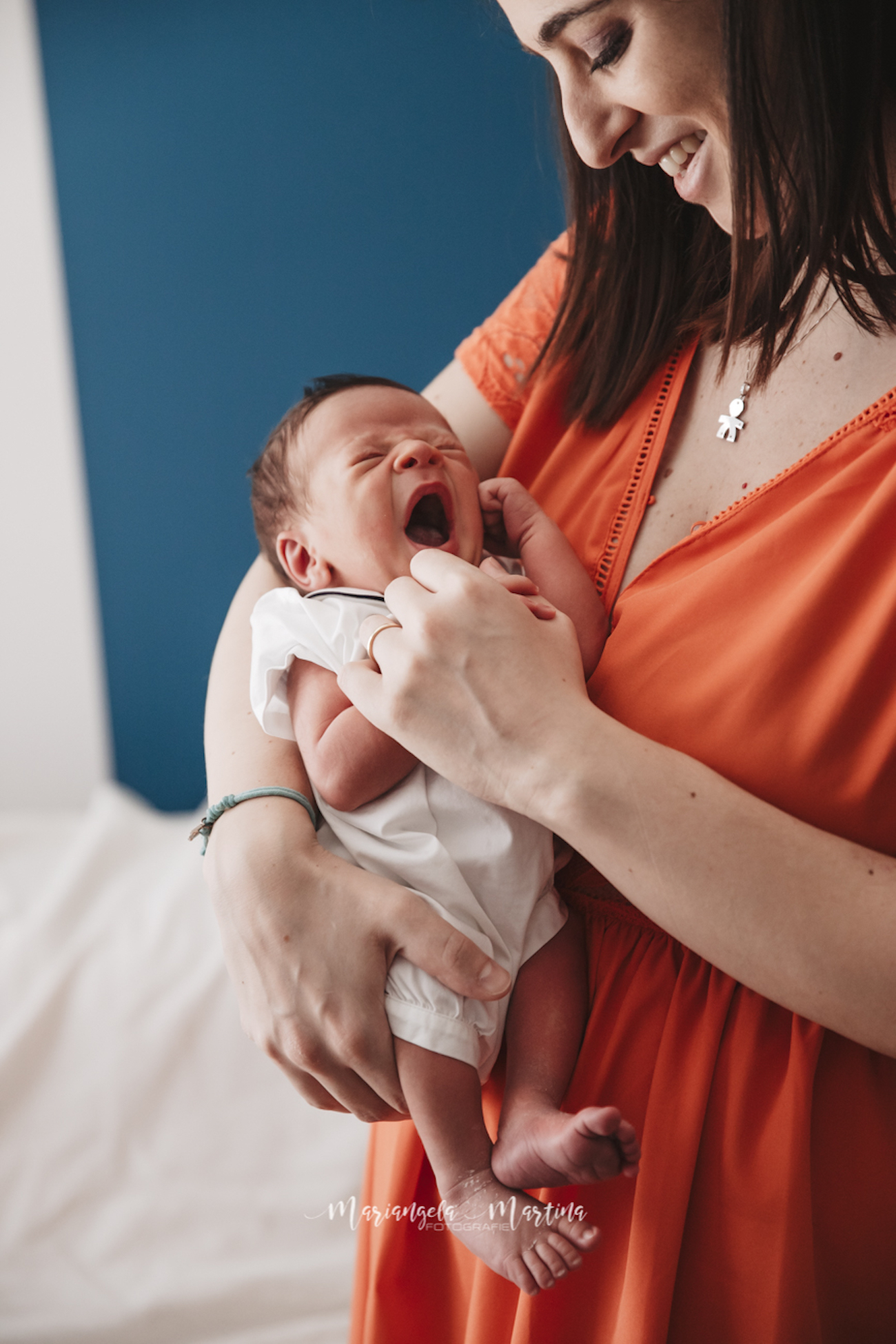 neonato che sbadiglia tra le braccia di mamma