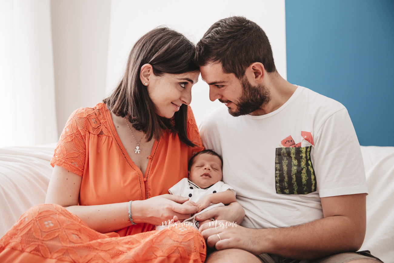 neonato con mamma e papà che si guardano con amore