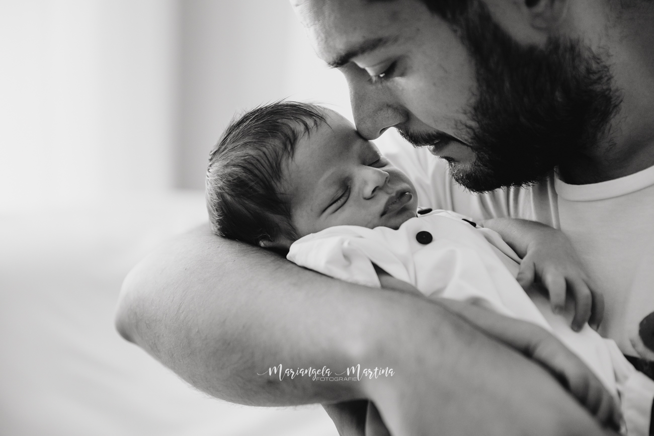papà abbraccia neonato